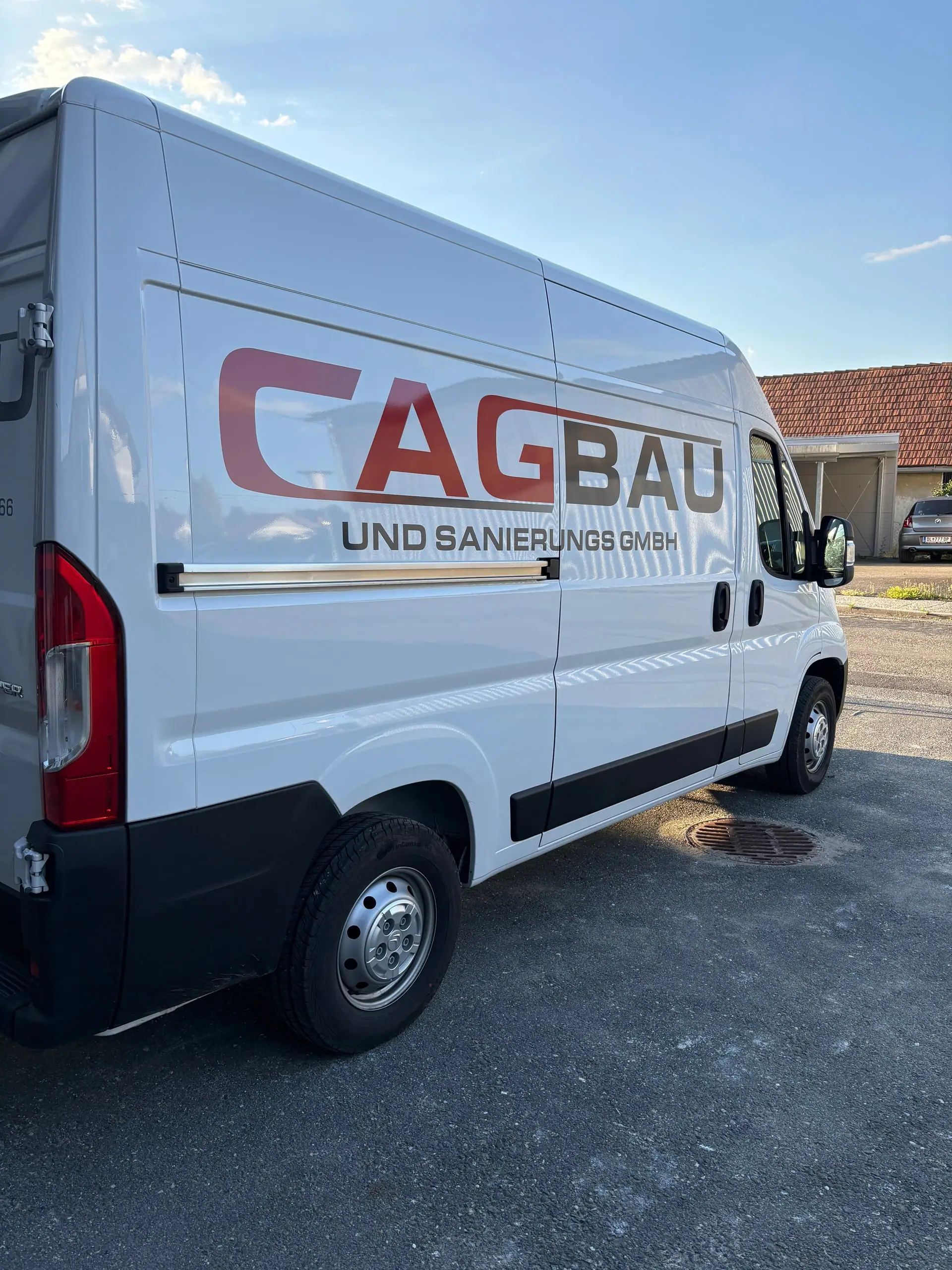 Weißer Kastenwagen mit rotem CAG-BAU-Schriftzug