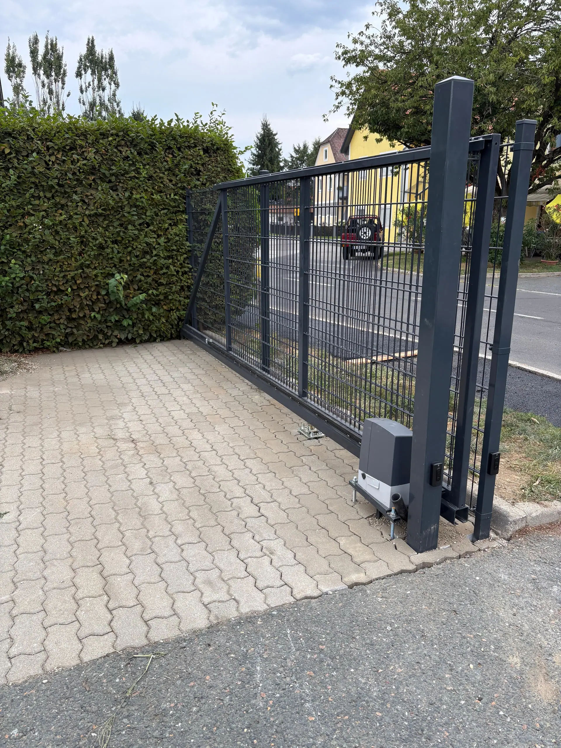 Geschlossenes Schiebetor, davor das fertige Pflaster