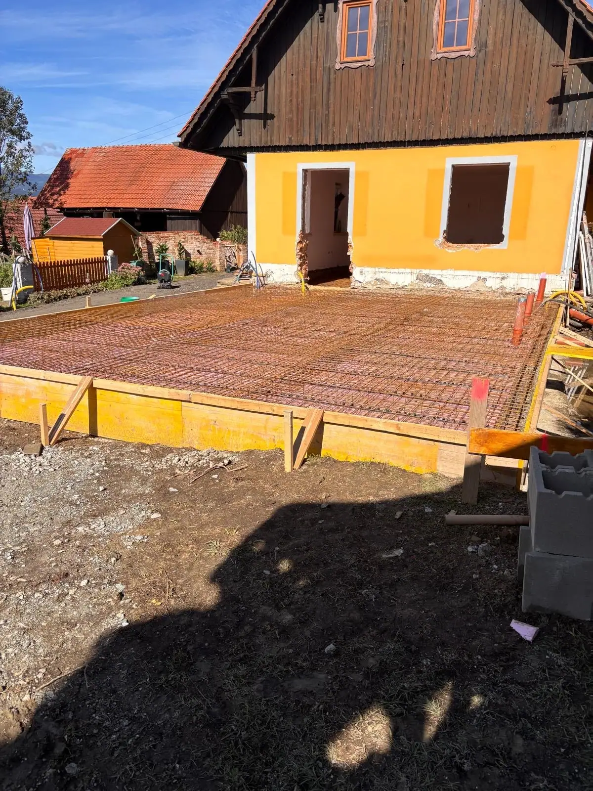 Bewehrung der Bodenplatte in der Schalung vor dem Haus