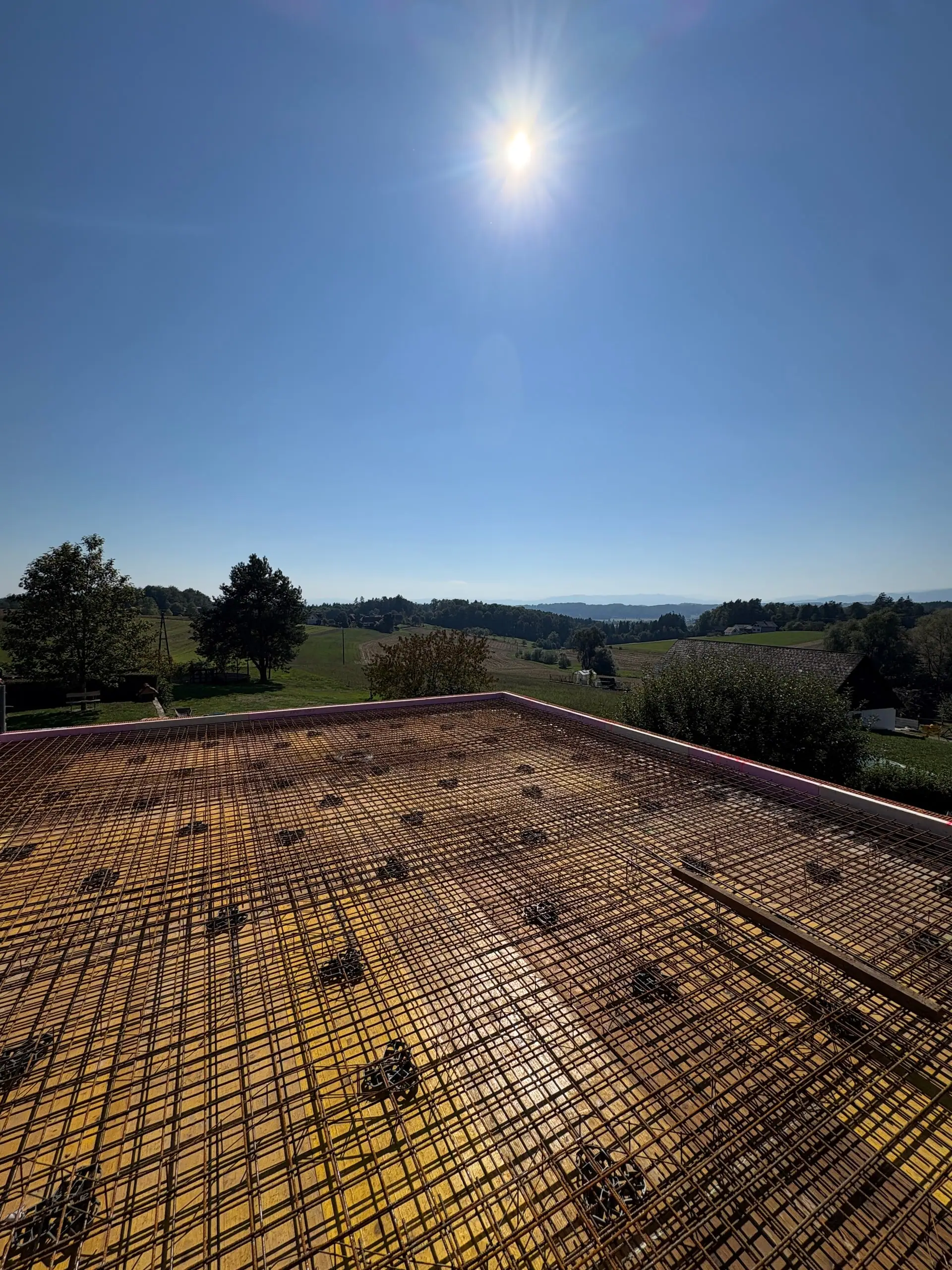 Bewehrte Decke über dem gemauerten Zubau im Gegenlicht, dahinter Hügel
