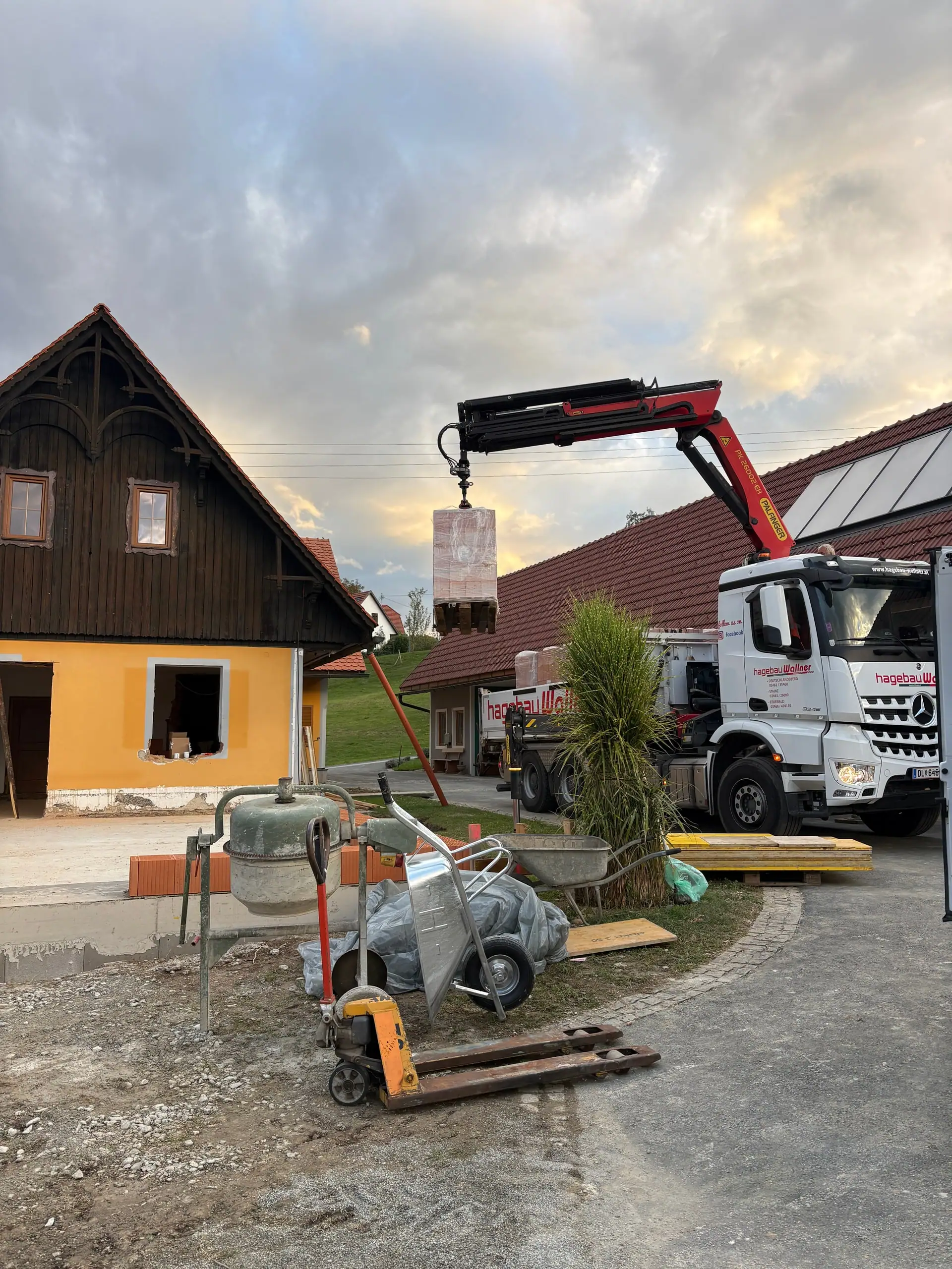 Lkw mit Ladekran liefert Ziegel auf die Baustelle